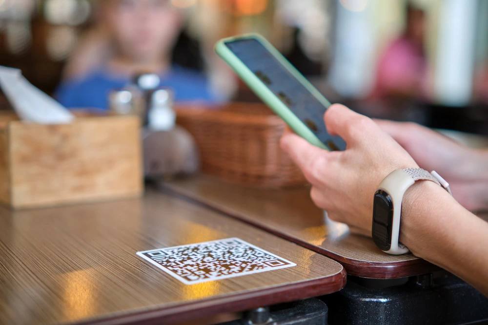 A diner scanning a QR code on a café table